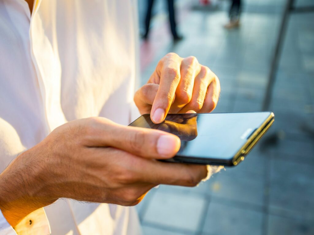 Hands holding a smart phone. VerseOne.ai builds AI customer service support with full voice support.