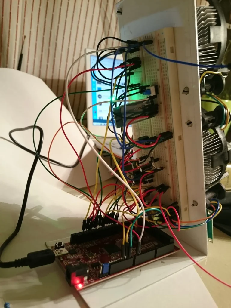 Arduino board wired to breadboard and fans with multicolored jumper cables.