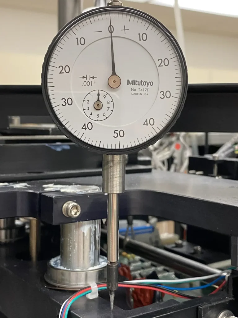 Mitutoyo dial indicator gauge mounted on a machine with probe and wiring.