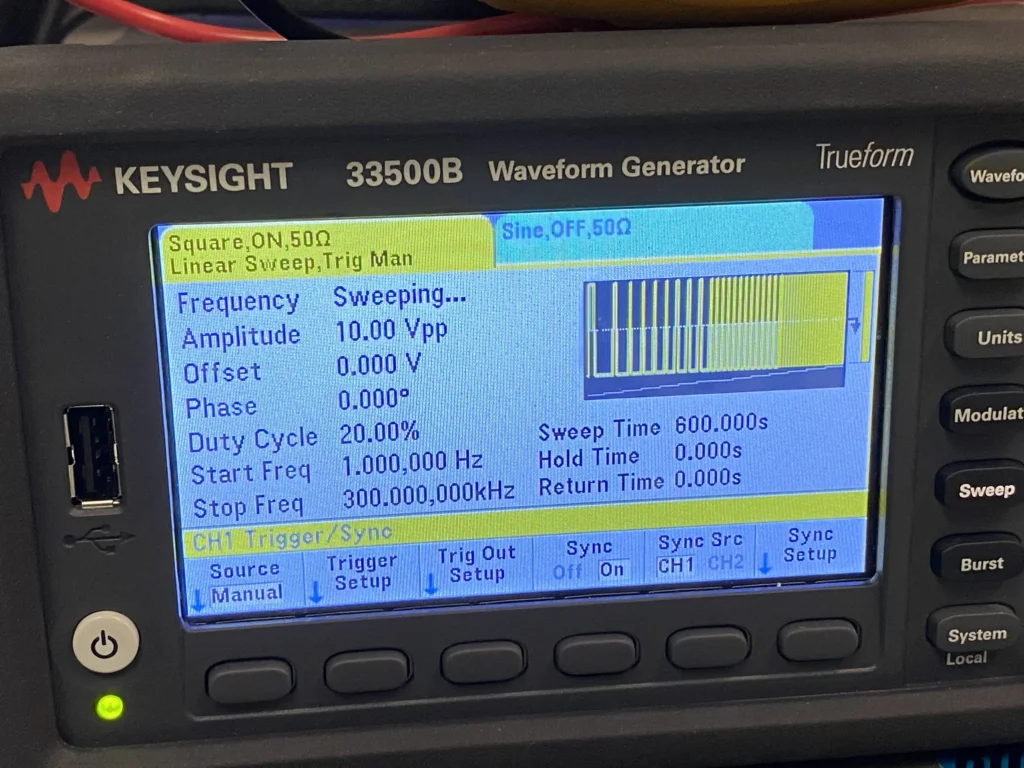 Keysight 33500B Trueform waveform generator displaying square wave sweep settings on its LCD screen.