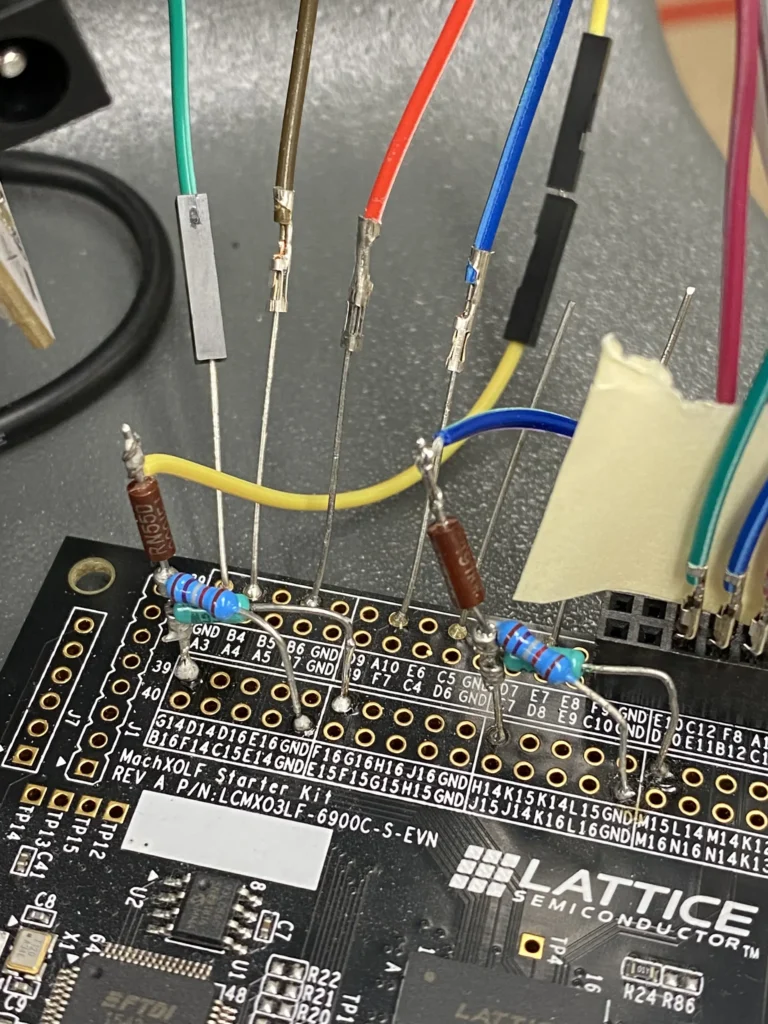 Lattice Semi LCMXO3LF starter board with colored resistors and jumper wires connected to pins.